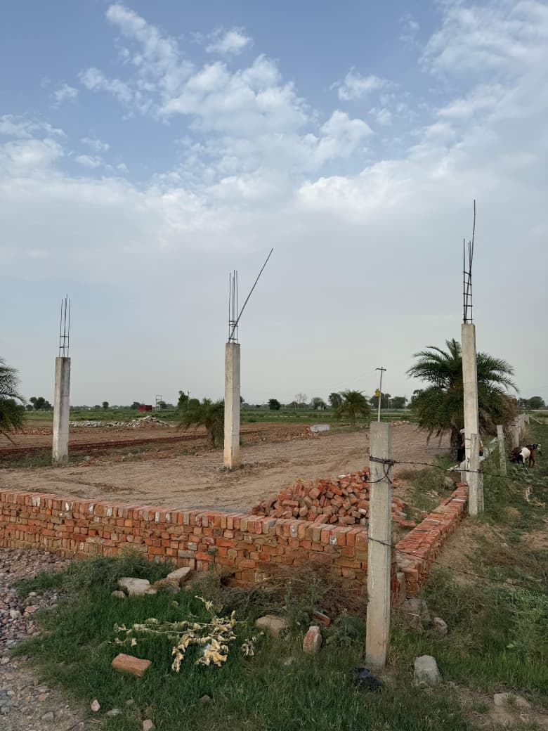 Internal township road and plot boundary at Hari Shyam Township